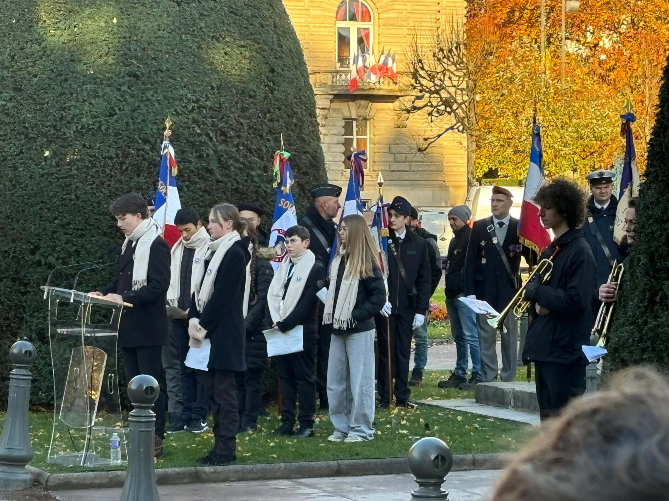 Eine Gruppe von Menschen bei einer Feier, einige in Uniform, andere halten Trompeten und Flaggen.